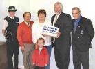 Pictured being presented with her prize by Mr. Mossie is Mrs. Carol Qua of Maybole. Included in the picture are Constable Hilary Sloan, Mr. Alex Kelly (Chairman) and Mr. Stan Bone.