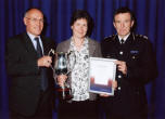 Presenting Linda with the trophy are Chief Constable Mick Creedon and former Chief Constable David Coleman